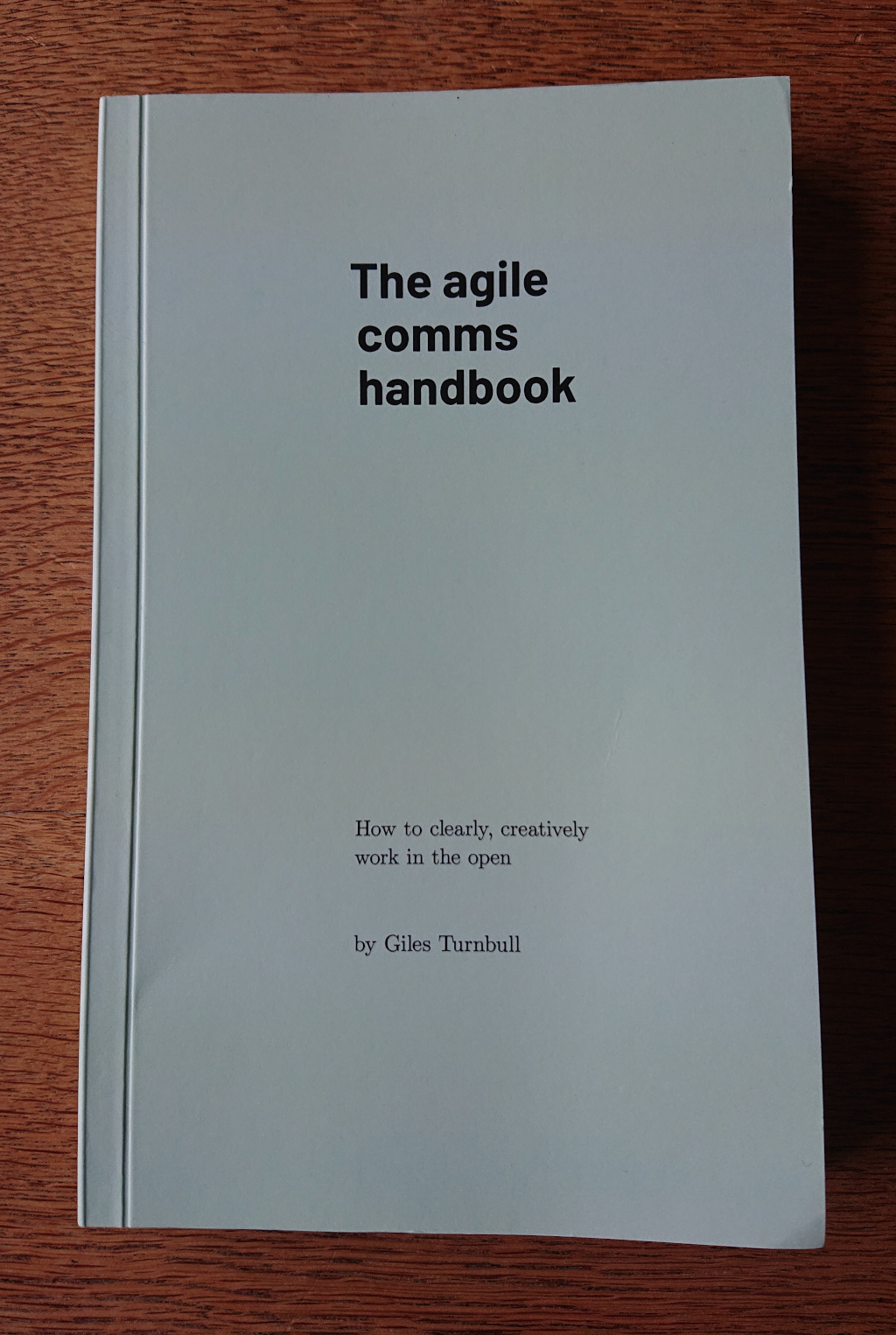 A photo of a pale-green-jacketed paperback copy of the agile comms handbook