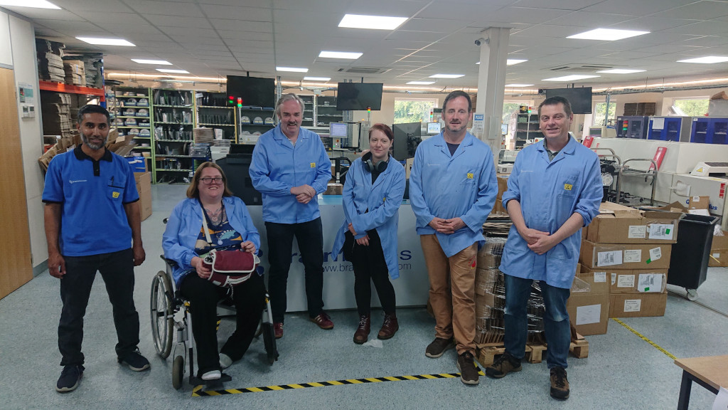 The MCQN team in blue lab coats on the factory floor of brainbox, where they manufacture their circuit boards.