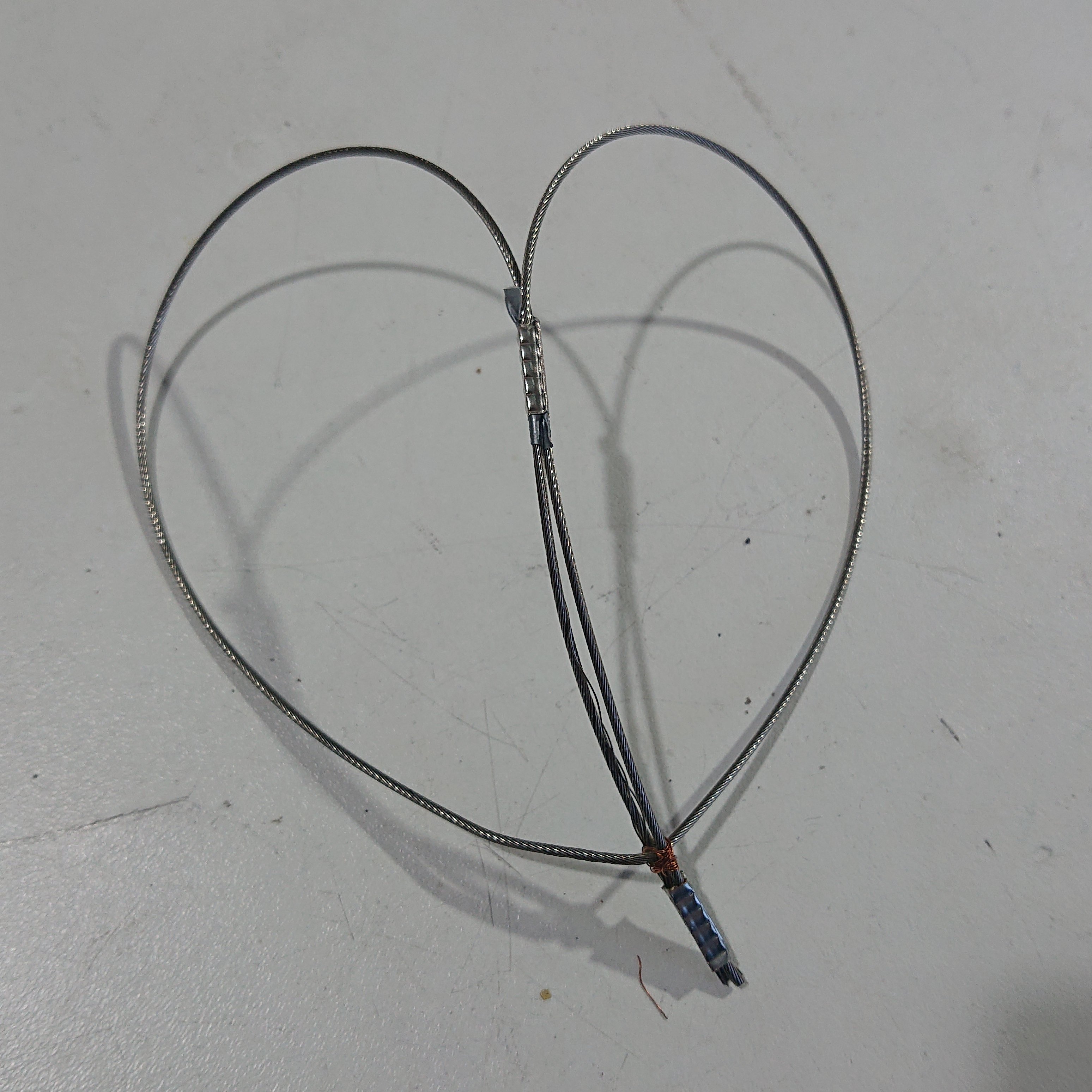 A wire brake cable looped round on itself, with a couple of ferrules crimped in judicious locations, to make a heart shape