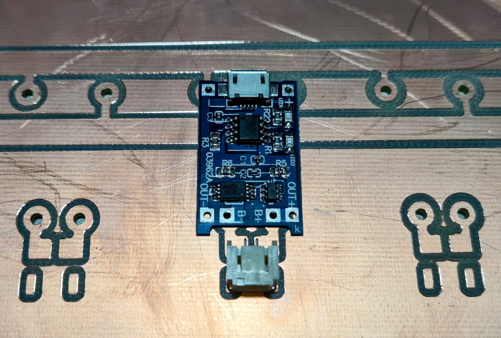 A CNC milled copper circuit board with a 4056 charging circuit and a JST connector