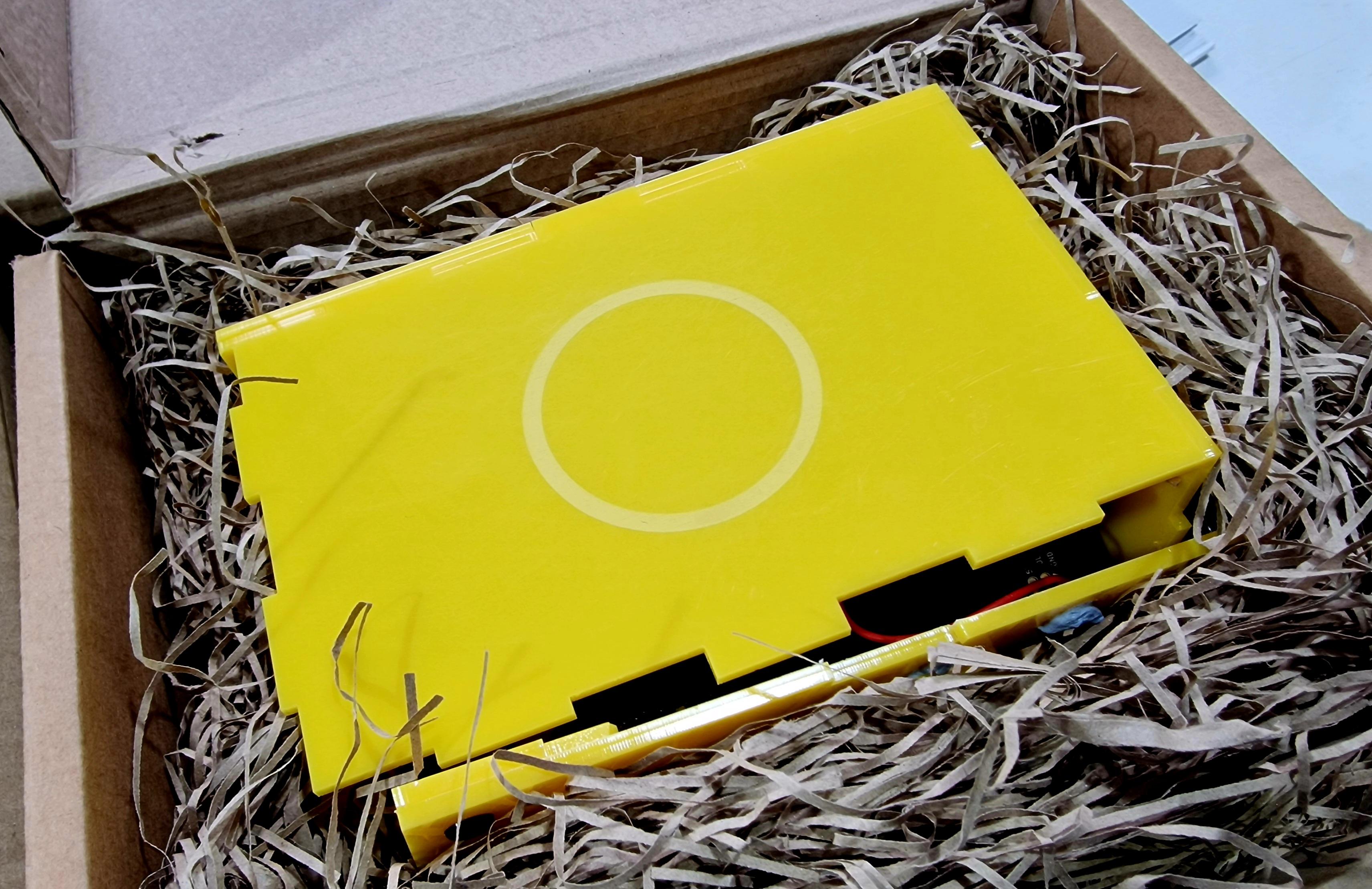 A yellow Museum in a Box in a nest of shredded cardboard packaging in for repair. The front and side of the box are detached and there are signs of snapped acrylic. Nothing we couldn't fix but certainly indications of having had a difficult run in with an immovable object