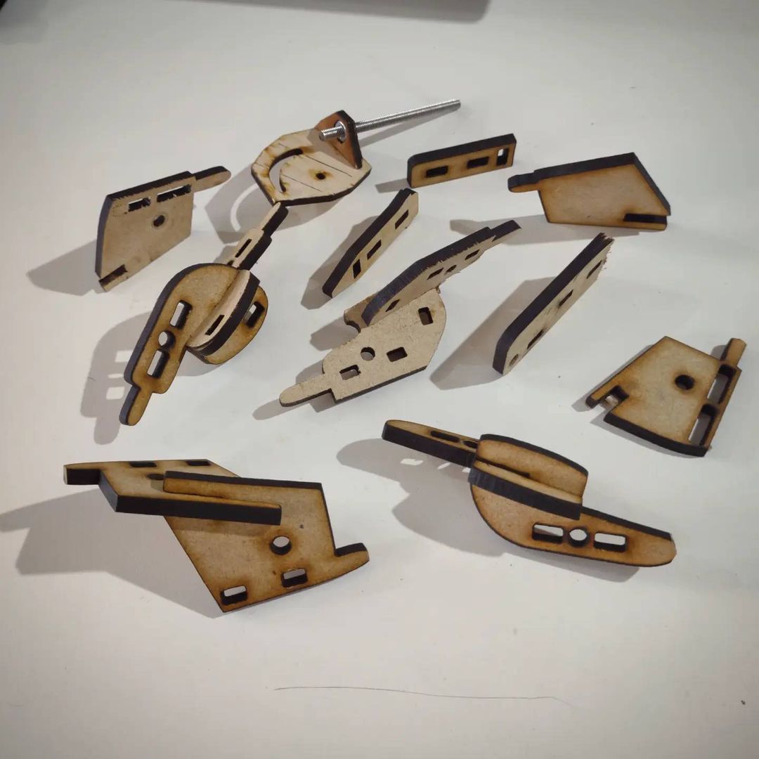 An array of laser-cut parts for the Ackers Bell, each varying in shape slightly or with different mounting holes